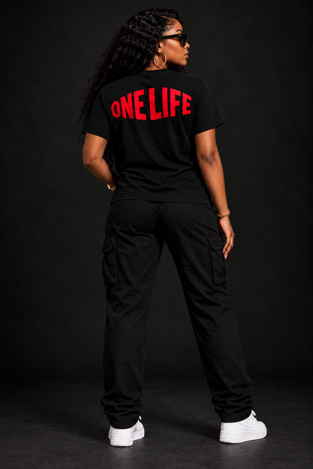 Women's model wearing the After Hours Tee by One Life Clothing — back view.