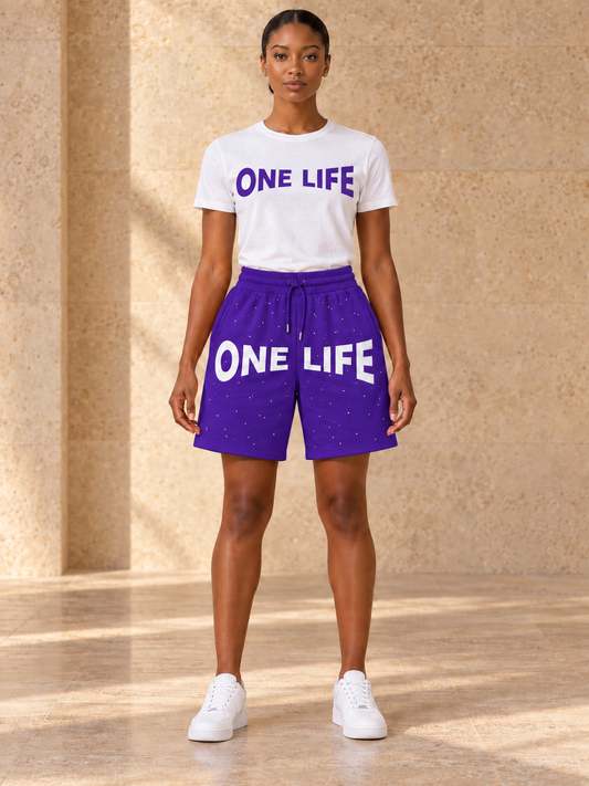 Women's Dream Chaser purple shorts with a white One Life shirt featuring a matching purple logo, front view.